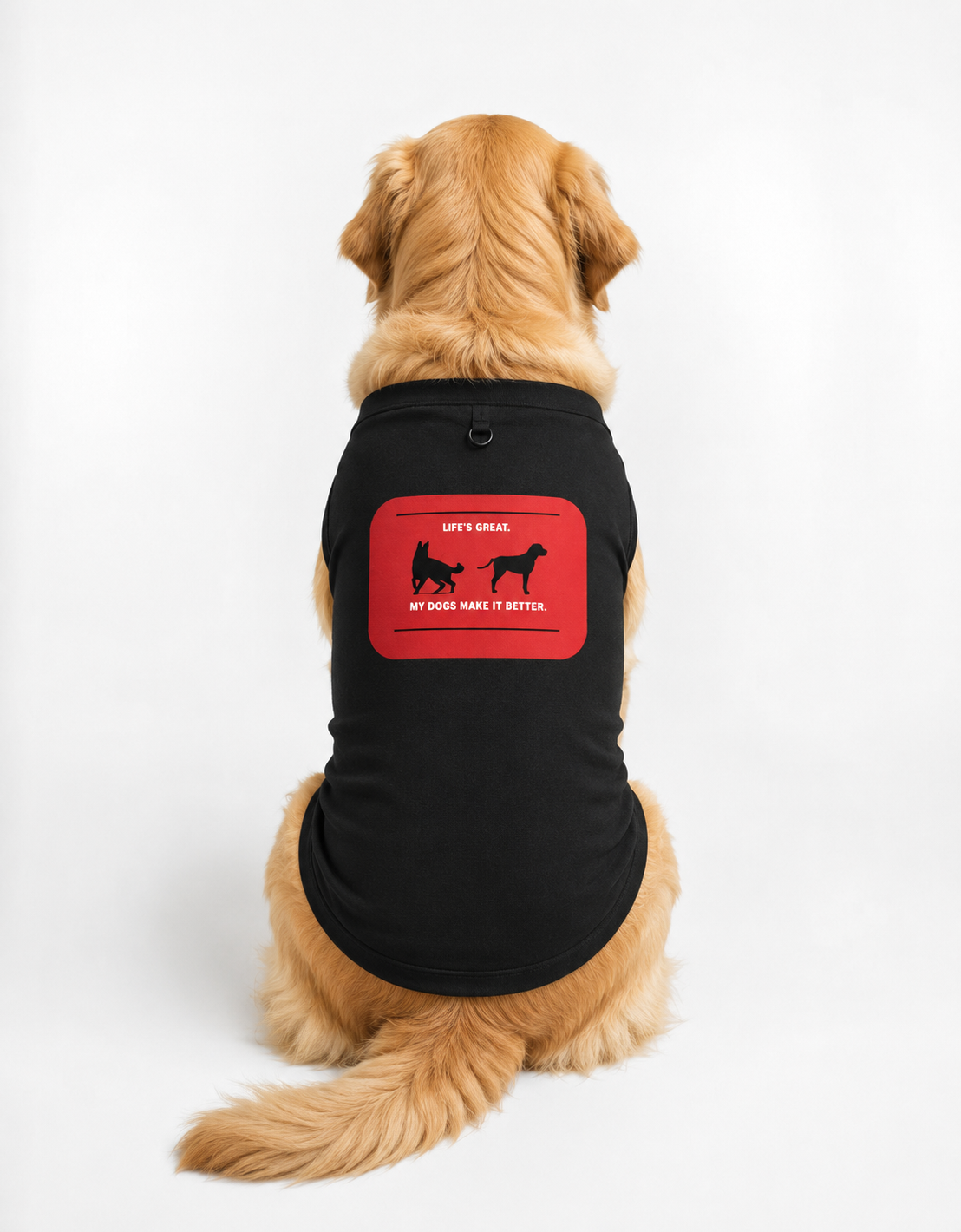 A golden retriever dog wearing a navy blue pet shirt with a red graphic patch on the back, photographed against a clean white studio background.